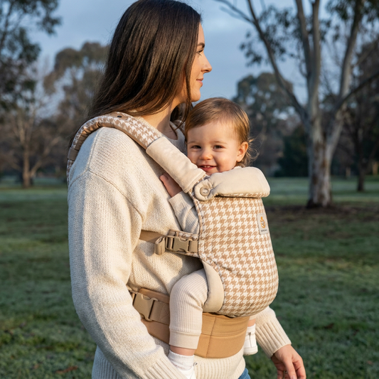 Mum wearing The Nest Carrier by Bubico with a happy toddler in a Melbourne park on a crisp winter morning